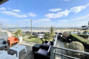 a balcony with chairs and a view of the beach at LUXURY T3 neuf de standing Front de mer vue 180 in Larmor-Plage