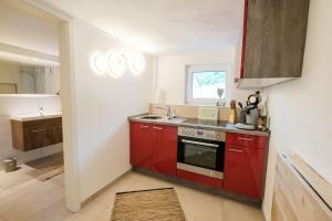- une cuisine avec des placards rouges et une cuisinière rouge dans l'établissement Terraluna-Heimbach, à Heimbach