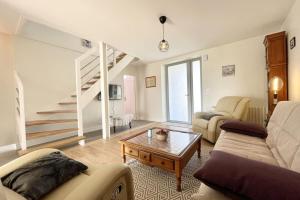 uma sala de estar com um sofá e uma mesa de centro em Maison de charme vue mer 180 rénovée Accès plage em Riantec