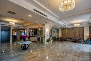 eine Lobby eines Hotels mit einem Tisch und einem Kronleuchter in der Unterkunft ALBA HOTEL & SPA in Baku