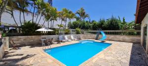 a swimming pool with a water slide in a yard at Linda Chácara em IBIUNA com Sauna - Piscina - WiFi - Caseiro in Ibiúna