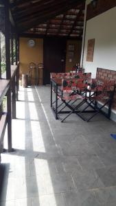 un groupe de tables et de chaises dans un bâtiment dans l'établissement Recanto dos Carvalhos - Pousada Camping, à São Lourenço