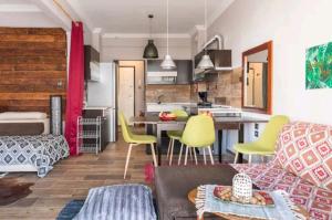 ein Wohnzimmer mit gelben Stühlen und eine Küche in der Unterkunft Flat on Walkstreet freeparking in Thessaloniki
