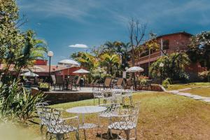 un grupo de mesas y sillas con sombrillas en Pousada Villa Mariana, en Pirenópolis