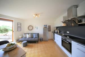 a kitchen and living room with a couch in it at Ganze Wohnung am Wörthersee in Pörtschach am Wörthersee