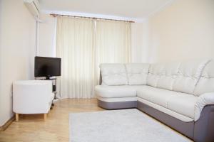 a living room with a white couch and a tv at KvartiraSvobodna - Apartment at Bolshoy Kondratyevskiy in Moscow