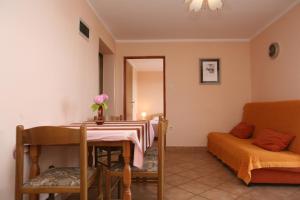 a dining room with a table and a couch at Apartments Neda - Poreč South in Poreč