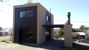 una pequeña casa en blanco y negro con garaje en Cabaña El Tordillo in 