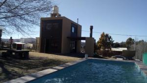 a house with a swimming pool in front of a house at Cabaña El Tordillo in Potrero de Garay