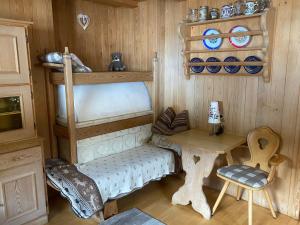 een speelkamer met een stapelbed en een tafel bij Appartamenti Hacoli in Selva di Val Gardena