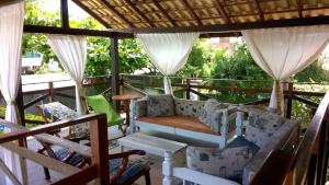 un portico con divano e sedie sopra di Dell Osky Pousada a Florianópolis