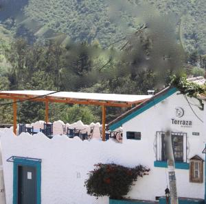 a white building with a blue roof and a mountain at Suite in beautiful Historical Guapulo, Quito in Quito