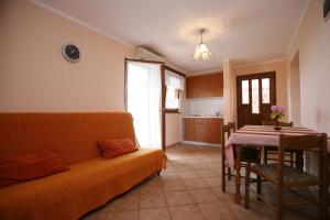Apartments Neda - Poreč South في بوريتش: غرفة معيشة مع أريكة وطاولة