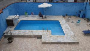 an overhead view of a swimming pool with an umbrella at Cantinho do Nick in Itanhaém