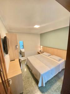um quarto de hotel com uma cama e uma televisão em Hotel Cocal em Fortaleza