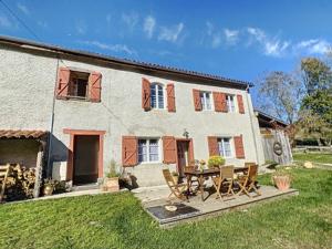 a house with a table and chairs in the yard at Gîte de montagne « Les Pivoines » à Nistos in Nistos