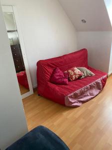 - un canapé rouge avec deux oreillers dans l'établissement Chambre Guestroom, à Nandy