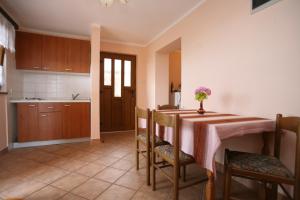 a kitchen with a table with a vase of flowers on it at Apartments Neda - Poreč South in Poreč