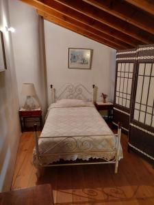 - une chambre avec un lit et 2 tables avec des fenêtres dans l'établissement Constantias stone houses, à Lófou