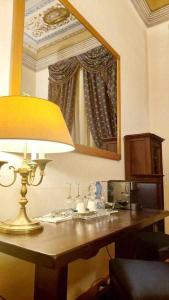 lámpara sobre una mesa en una habitación con espejo en Tornabuoni La Petite Suite, en Florencia