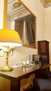 lámpara sobre una mesa en una habitación con espejo en Tornabuoni La Petite Suite en Florence