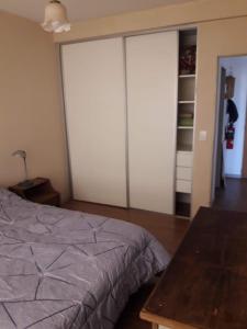 een slaapkamer met witte kasten en een bed en een tafel bij Departamento de Barrio Belgrano in Bariloche