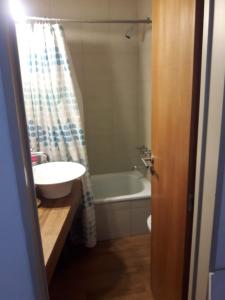 een badkamer met een wastafel en een ligbad bij Departamento de Barrio Belgrano in Bariloche