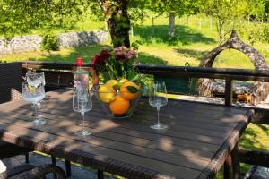 una mesa con un bol de frutas y copas de vino en FoRest Chalet en Zalesina