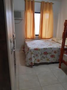 - une chambre avec un lit et une fenêtre avec des rideaux dans l'établissement Apartamento Térreo em Ponta das Canas, à Florianópolis