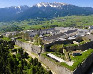 an old castle with a town and mountains in the background at Logement cosy au pied des pistes in Saint-Pierre-dels-Forcats