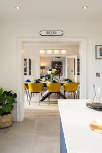 a dining room with a table and yellow chairs at Escape Ordinary at Lily's Pad in Enniskillen