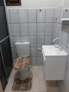 La salle de bains est pourvue de toilettes et d'un lavabo. dans l'établissement Apartamento Térreo em Ponta das Canas, à Florianópolis