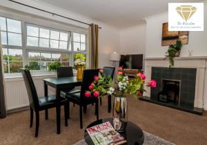 a living room with a table and chairs and a fireplace at 2 Bed Apartment-5 Guests - Business-Relocation-Parking - The Brighton Short Stay & serviced Apartments in Brighton & Hove