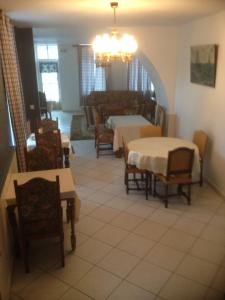 a dining room with tables and chairs and a chandelier at Les Chambres d'Hôtes de l'Elysée in Pontrieux