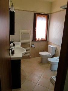 bagno con lavandino, servizi igienici e finestra di R&B Tana delle Fate a Camugnano