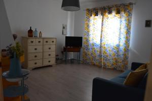 a living room with a couch and a dresser at Casa da Cerca in Corte do Pinto