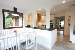 a kitchen with a white counter and a dining room at WEIßE HÖHEN -Ferienhaus, Dibbersen bei Hamburg in Buchholz in der Nordheide