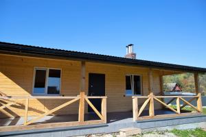 Cabaña de madera con porche y valla de madera en Rancho Resort en Bilichi