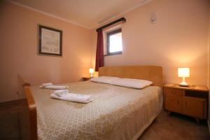 a bedroom with a bed with two towels on it at Apartments Neda - Poreč South in Poreč