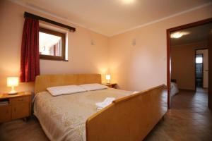 a bedroom with a bed with two lamps and a mirror at Apartments Neda - Poreč South in Poreč