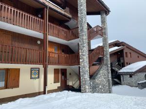 a large building with snow in front of it at Valmorel Studio Skis aux pieds in Valmorel