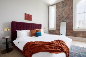 a bedroom with a large bed and a brick wall at Sonder Gravier Place in New Orleans