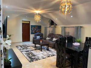 ein Wohnzimmer mit einem Sofa und einem Tisch in der Unterkunft Tsavo House-A cosy home 15 min from the JKIA Airport and SGR Terminus in Syokimau