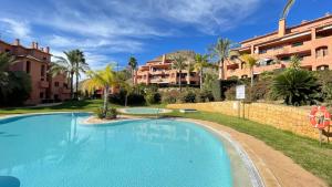 a swimming pool in a resort with palm trees and buildings at Luxyry apartament Benidorm in Finestrat