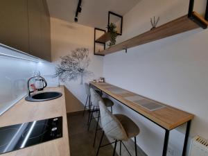 a kitchen with a sink and a counter with stools at Studio Apartman Golden Lux 1 in Pale +9 photos