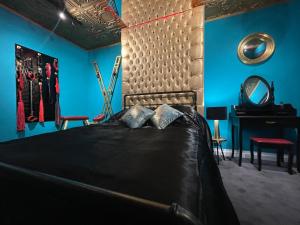 a bedroom with a bed with blue walls and a mirror at Boutique Dungeon in Brighton & Hove