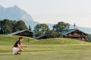 ミッタージルにあるPension Oberbräuの女がゴルフ場でゴルフをしている