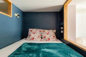 a small bedroom with a bed with a blue wall at Ma Petite Versailles in Versailles