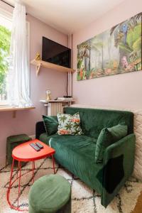 a living room with a green couch and a table at Ma Petite Versailles in Versailles