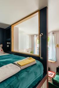 a bedroom with a large mirror on a bed at Ma Petite Versailles in Versailles